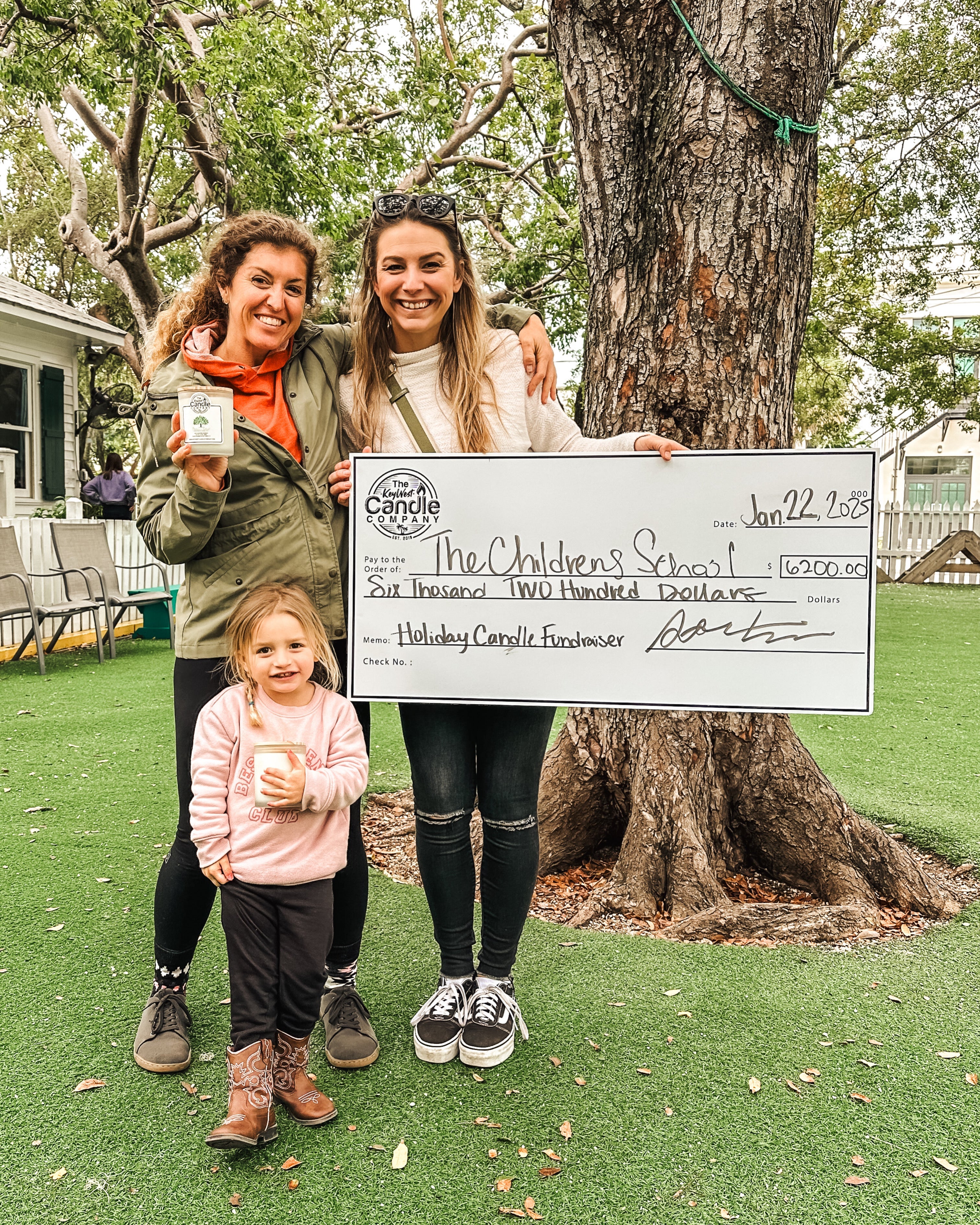 A Key West Candle fundraiser presenting a donation check to a local school